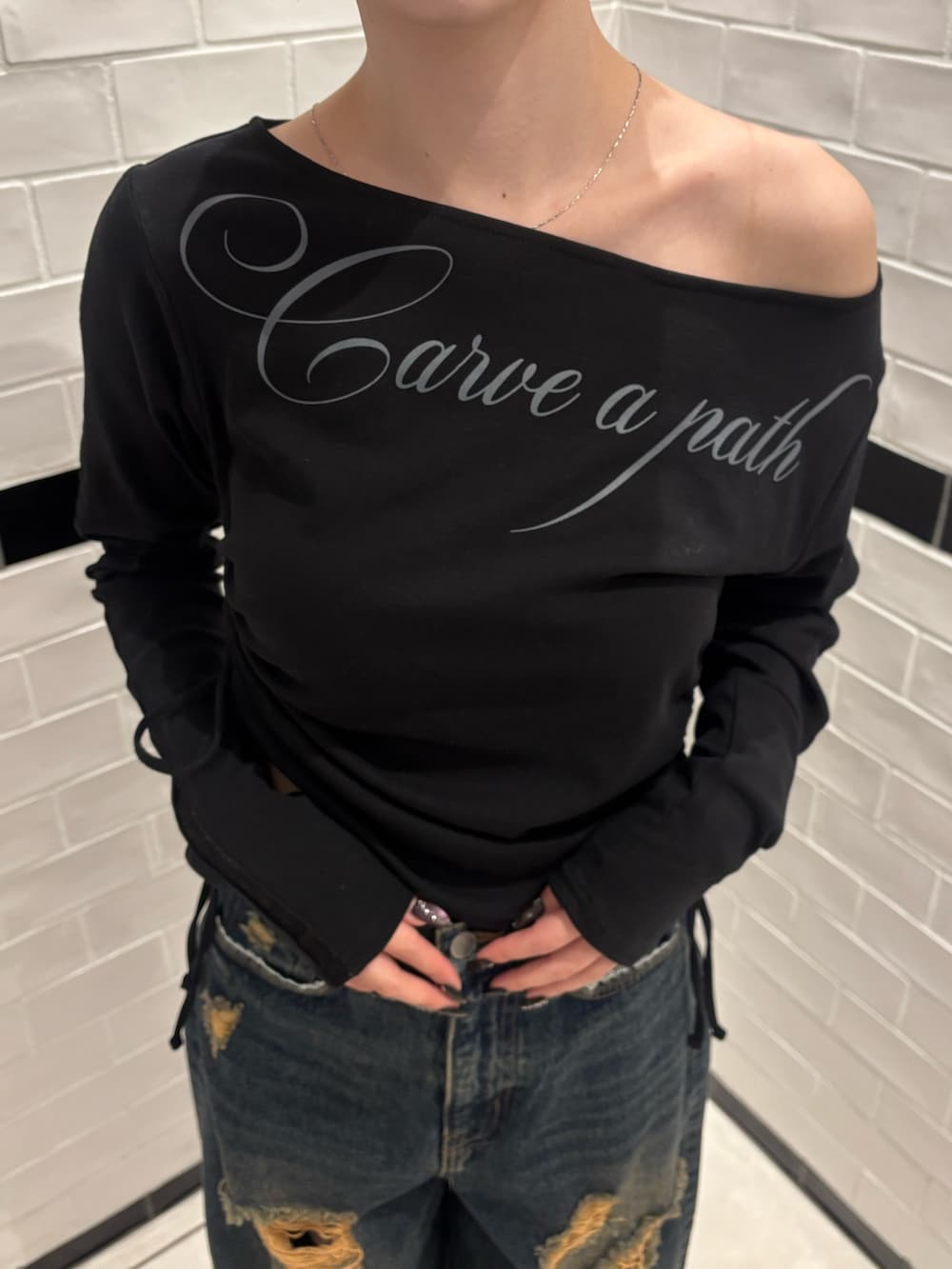 ブラック系のTシャツ/カットソー、ブルー系のデニムパンツ、ブラック系のスニーカーを着用したレディースの春コーディネートの4枚目の写真