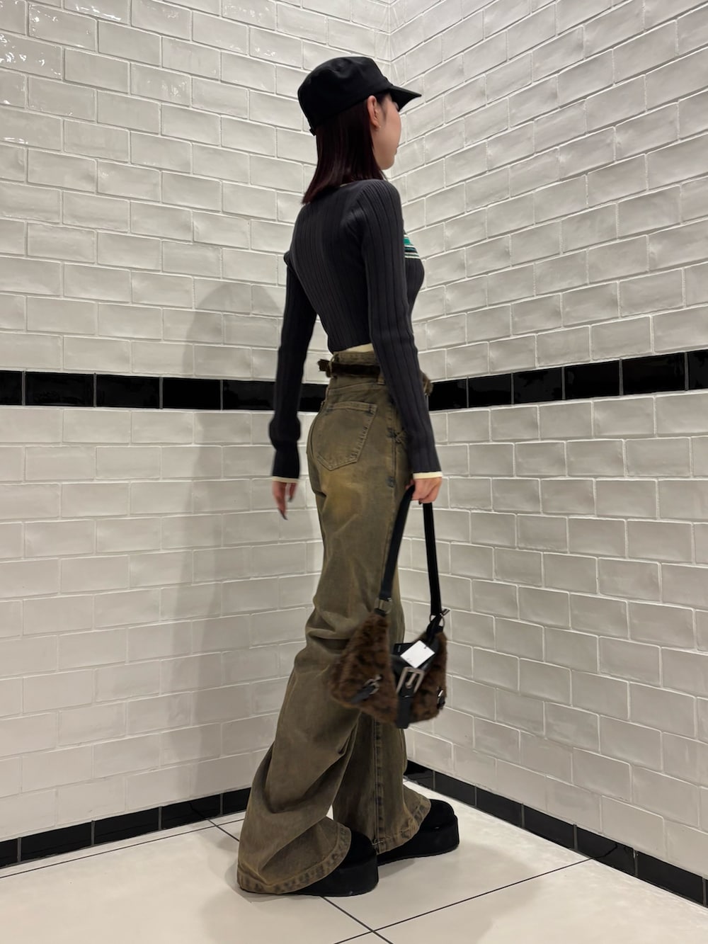 グレー系のニット/セーター、ベージュ系のデニムパンツ、ブラック系のスリッポンを着用したレディースの秋コーディネートの2枚目の写真
