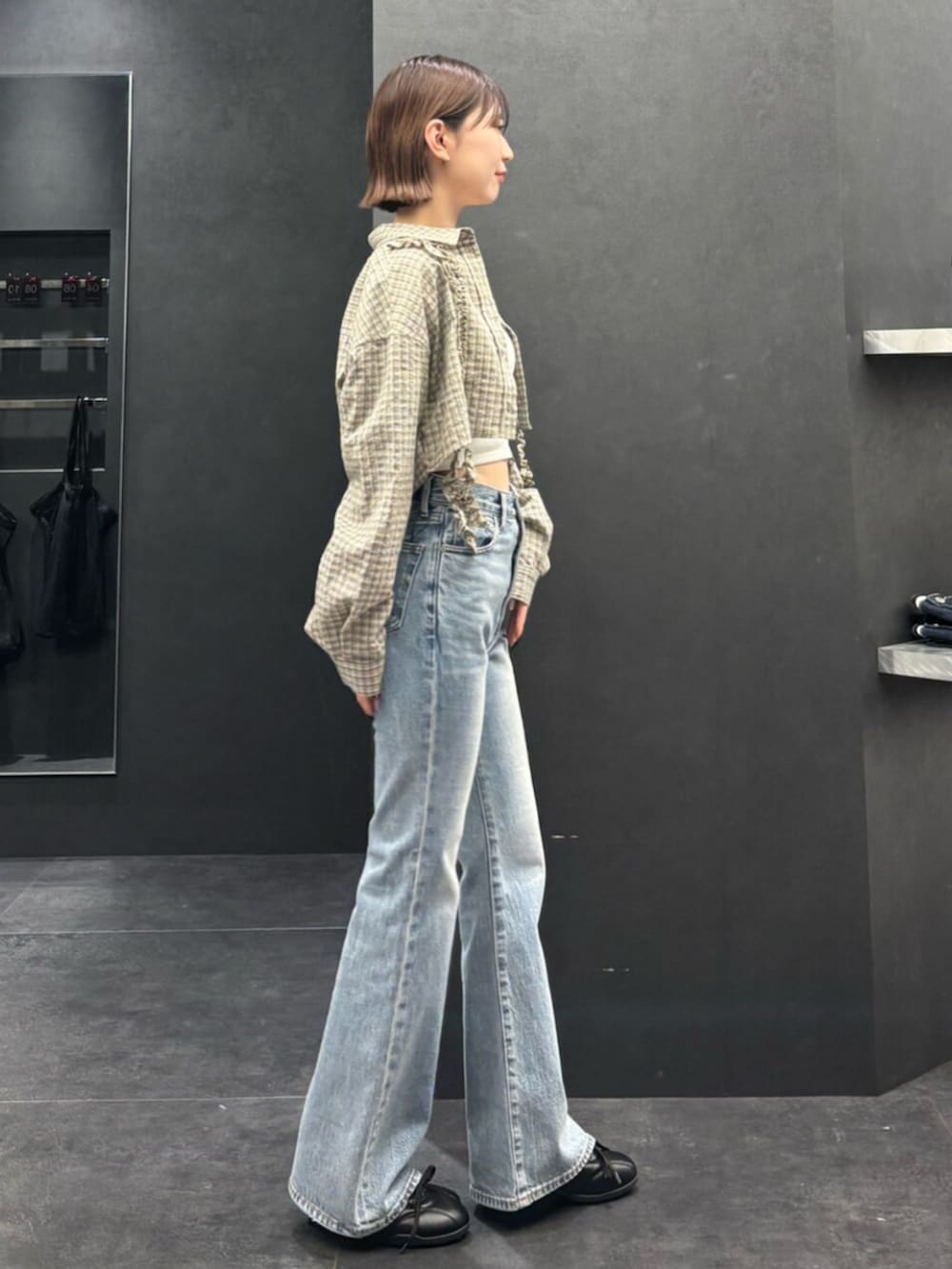 ブラック系のスニーカー、ブルー系のデニムパンツ、ベージュ系のシャツ/ブラウスを着用したレディースの春コーディネートの2枚目の写真