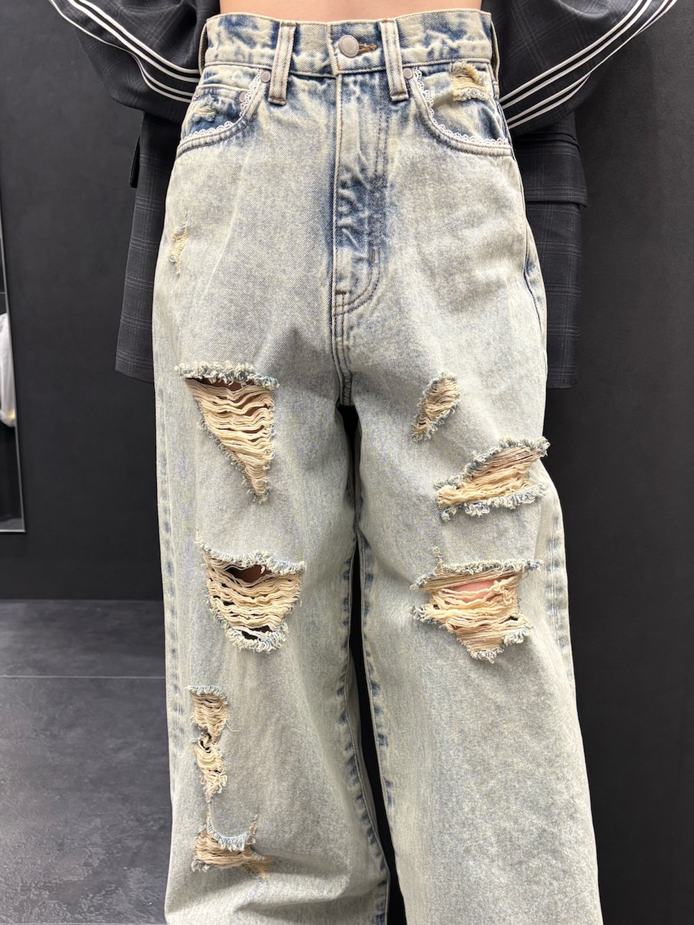 ブラック系のパーカー、ブルー系のデニムパンツ、ブラック系のスニーカーを着用したレディースの春コーディネートの5枚目の写真