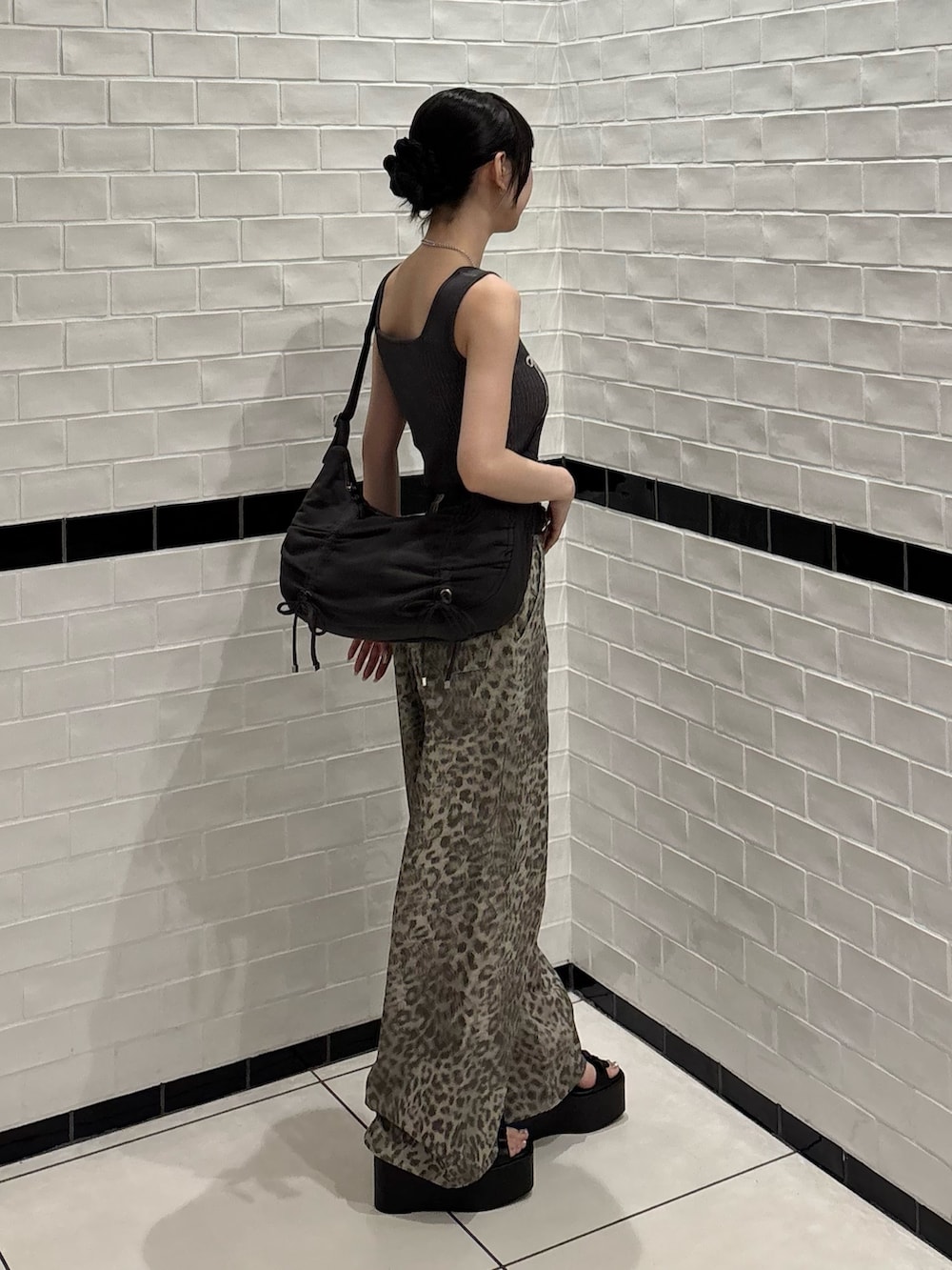 ベージュ系のその他パンツ、ブラック系のサンダル、ブラック系のハンドバッグを着用したレディースの夏コーディネートの2枚目の写真
