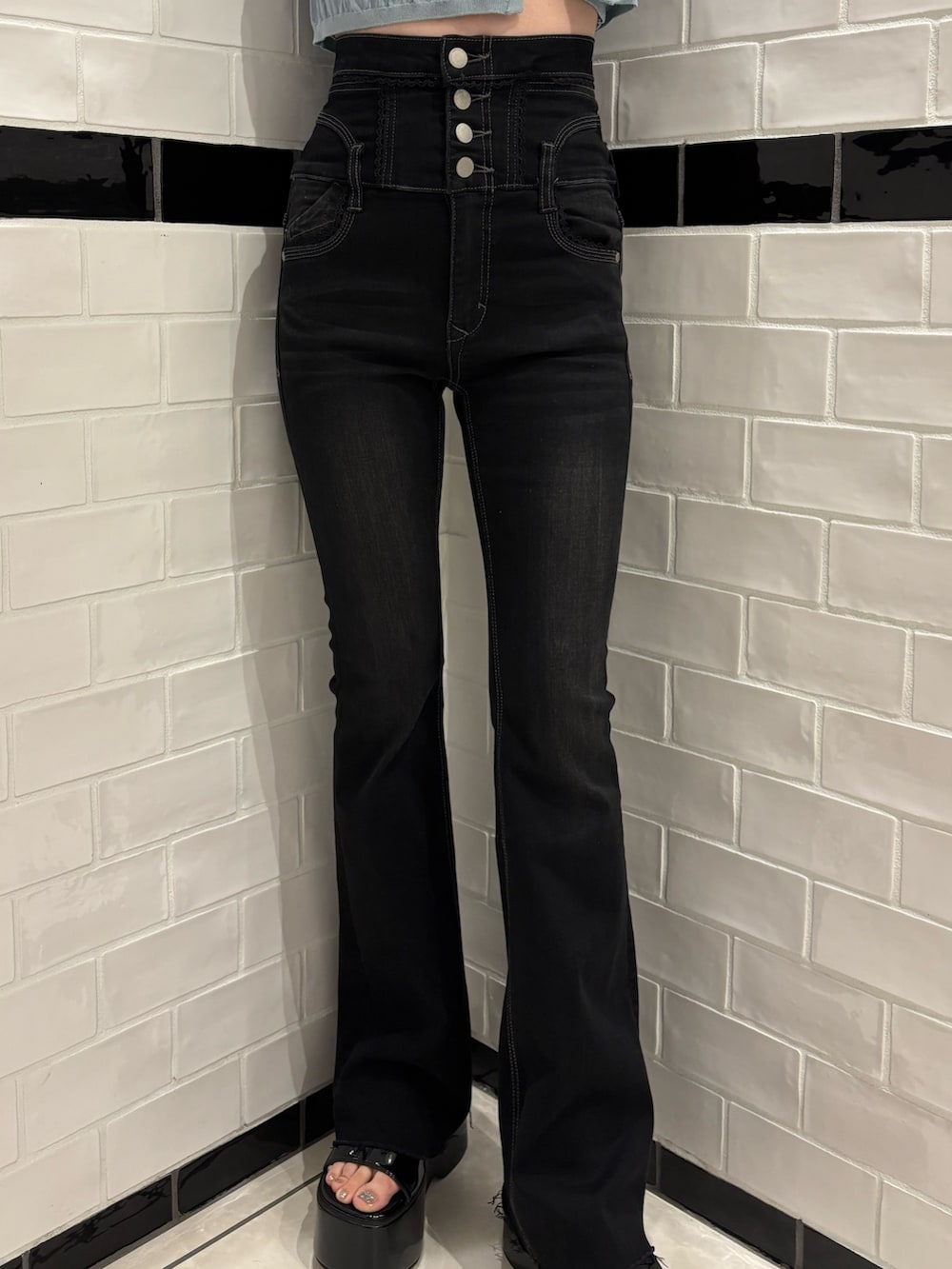 ブルー系のニット/セーター、ブラック系のデニムパンツ、ホワイト系のハンドバッグを着用したレディースの春コーディネートの5枚目の写真