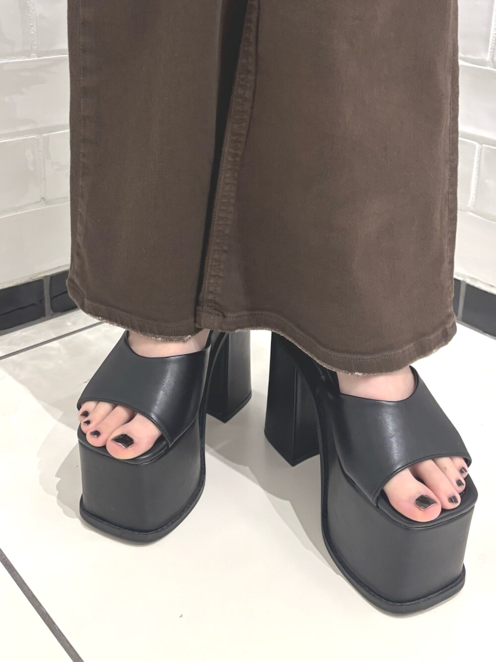 ブラック系のパーカー、ブラック系のサンダル、ブラウン系のサロペット/オーバーオールを着用したレディースの春コーディネートの5枚目の写真