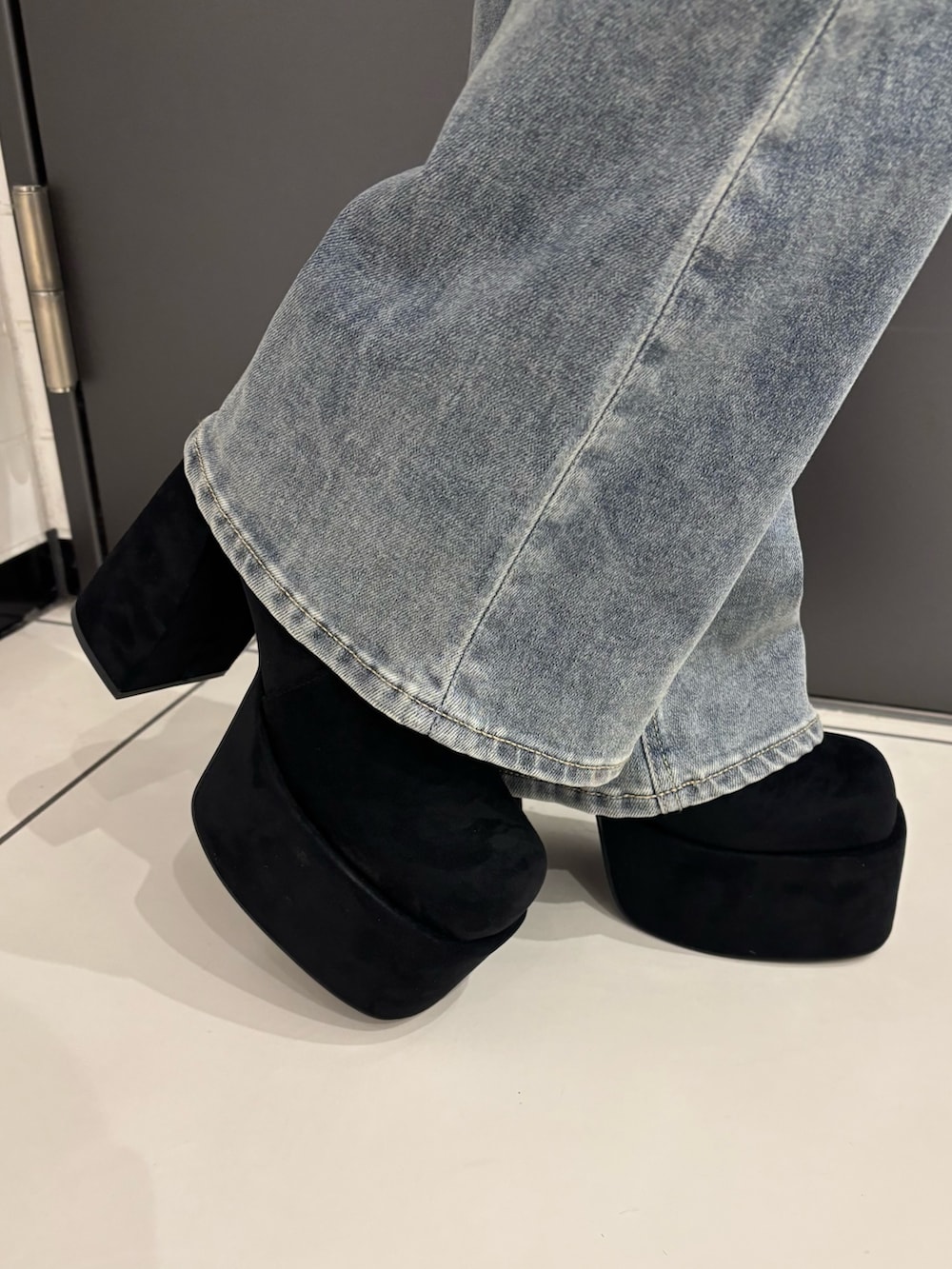 ブラック系のブルゾン、ブルー系のデニムパンツ、ブラック系のブーツを着用したレディースの秋コーディネートの6枚目の写真