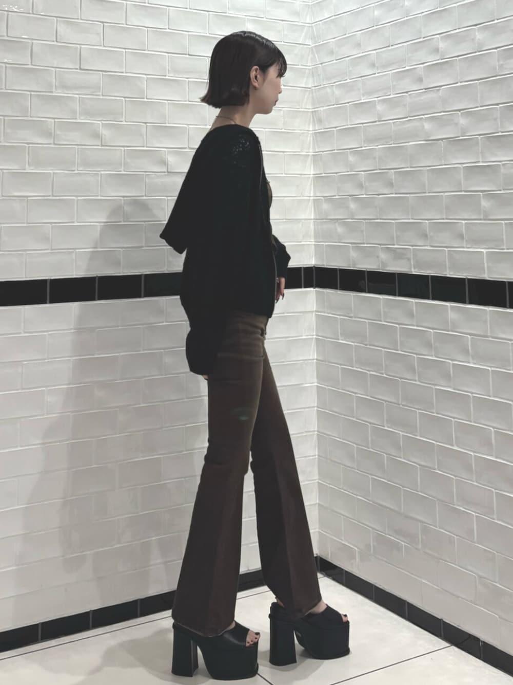 ブラック系のパーカー、ブラック系のサンダル、ブラウン系のサロペット/オーバーオールを着用したレディースの春コーディネートの2枚目の写真