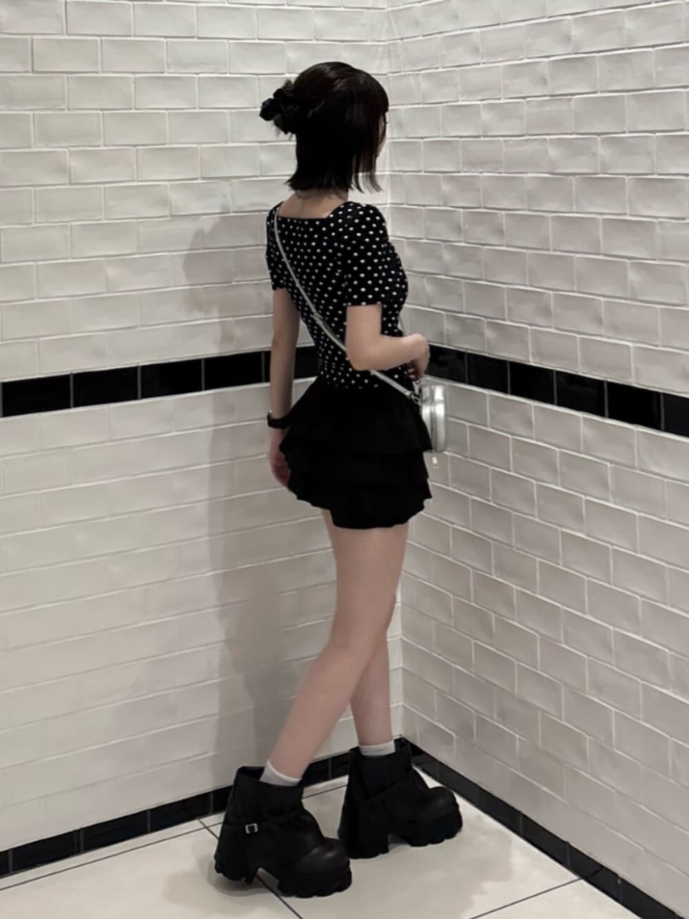 ブラック系のブーツ、シルバー系のショルダーバッグ、その他のTシャツ/カットソーを着用したレディースの夏コーディネートの2枚目の写真