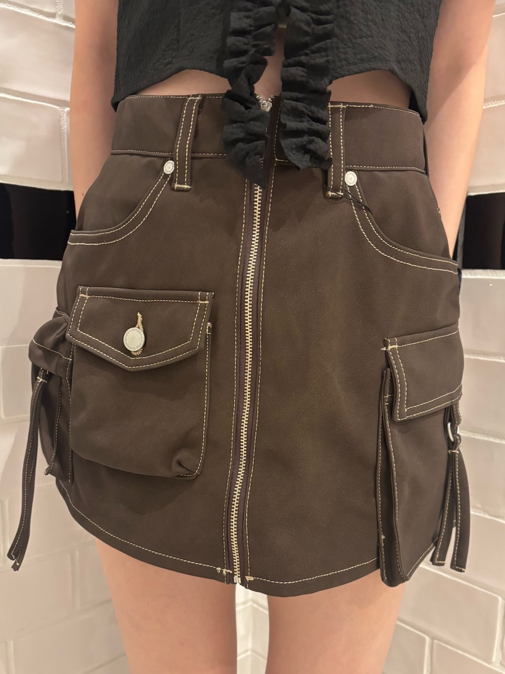 ブラック系のTシャツ/カットソー、ブラウン系のスカート、ブラック系のスニーカーを着用したレディースの夏コーディネートの5枚目の写真