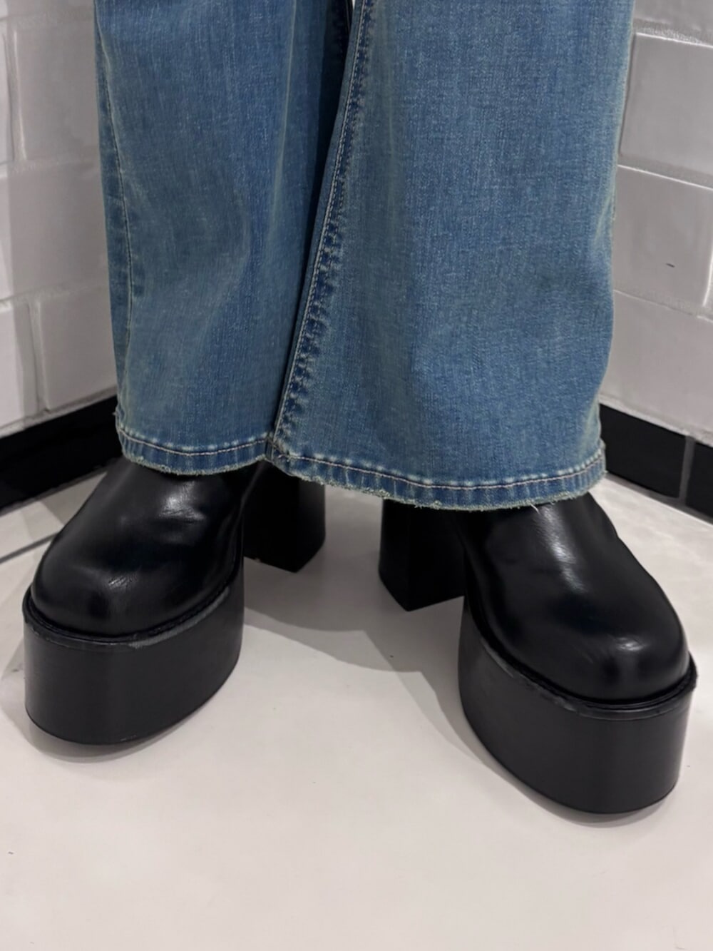 ブラック系のブーツ、ブラウン系のハンドバッグ、ブラック系のTシャツ/カットソーを着用したレディースの冬コーディネートの6枚目の写真