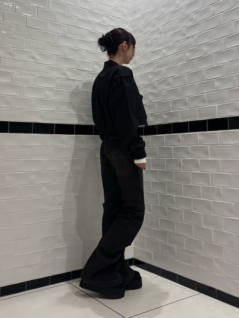 ブラック系のデニムパンツ、ブラック系のスリッポン、ブラック系のブルゾンを着用したレディースの秋コーディネートの2枚目の写真
