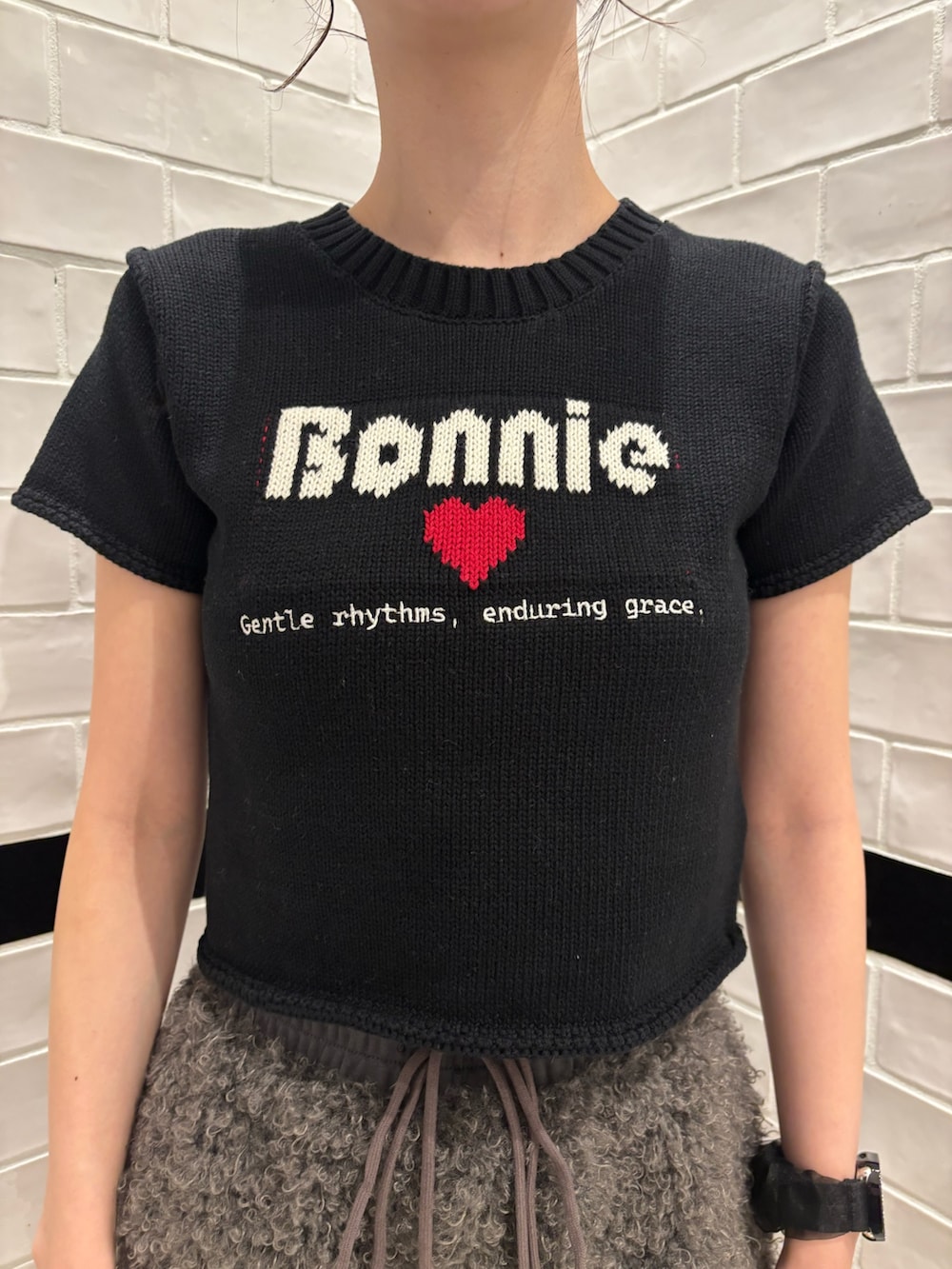 ブラック系のニット/セーター、グレー系のその他パンツ、ブラック系のスリッポンを着用したレディースの夏コーディネートの4枚目の写真