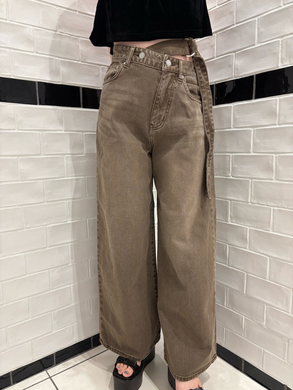 ブラック系のタンクトップ、ブラウン系のデニムパンツ、ブラック系のサンダルを着用したレディースの夏コーディネートの5枚目の写真