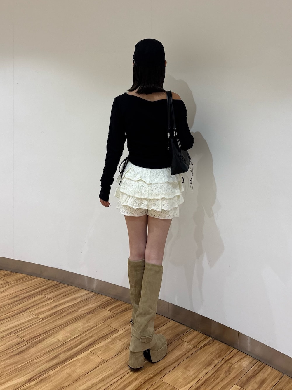 ブラック系のTシャツ/カットソー、ホワイト系のスカート、ベージュ系のブーツを着用したレディースの夏コーディネートの3枚目の写真