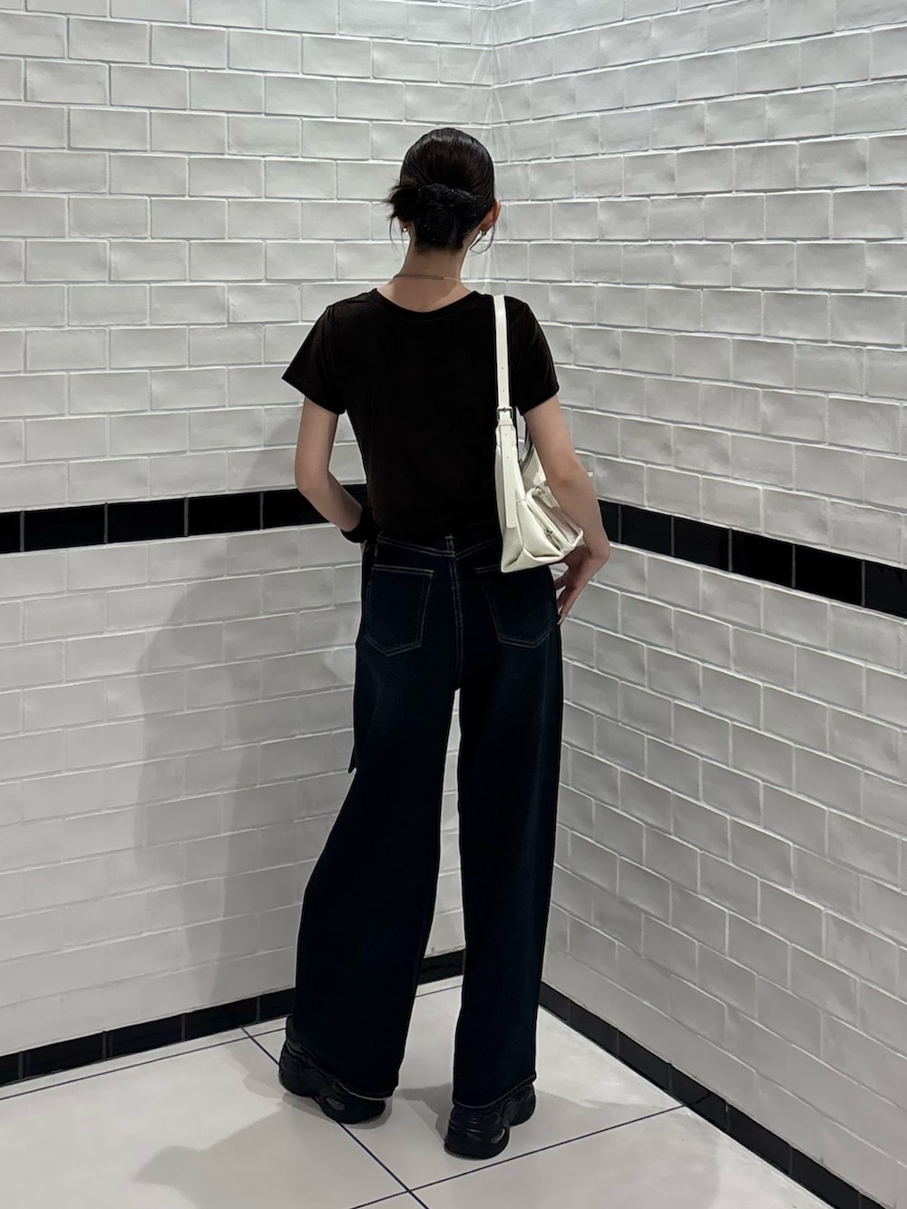 ブラウン系のTシャツ/カットソー、ブルー系のデニムパンツ、ホワイト系のハンドバッグを着用したレディースの夏コーディネートの3枚目の写真
