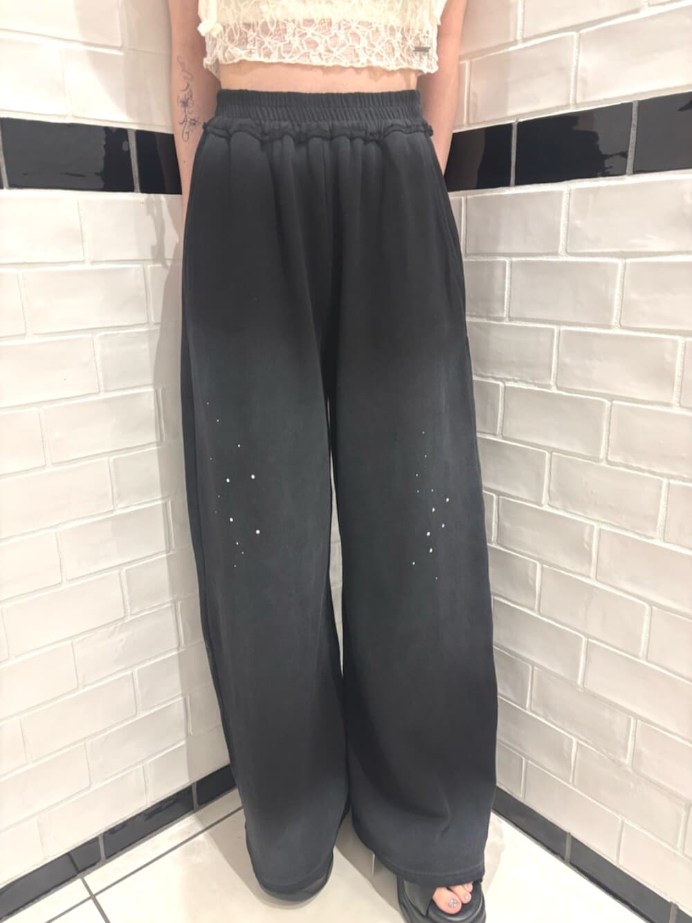 ブラック系のスウェットパンツ、ブラック系のサンダル、ホワイト系のTシャツ/カットソーを着用したレディースの夏コーディネートの5枚目の写真