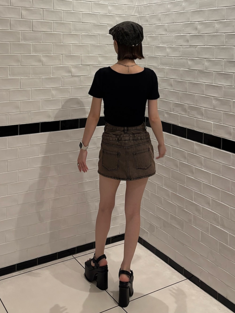 ブラック系のニット/セーター、ブラウン系のスカート、ブラック系のサンダルを着用したレディースの春コーディネートの4枚目の写真