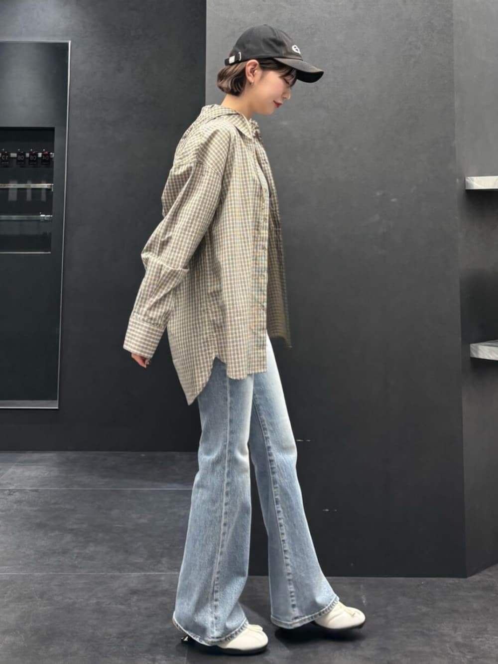 ブルー系のデニムパンツ、ベージュ系のシャツ/ブラウス、ブラック系のTシャツ/カットソーを着用したレディースの春コーディネートの2枚目の写真