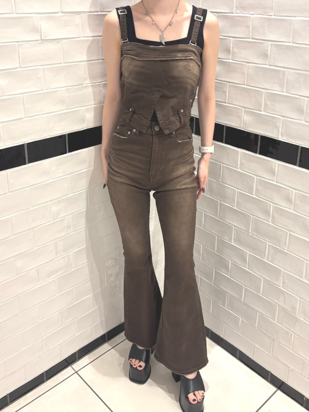 ブラック系のパーカー、ブラック系のサンダル、ブラウン系のサロペット/オーバーオールを着用したレディースの春コーディネートの4枚目の写真