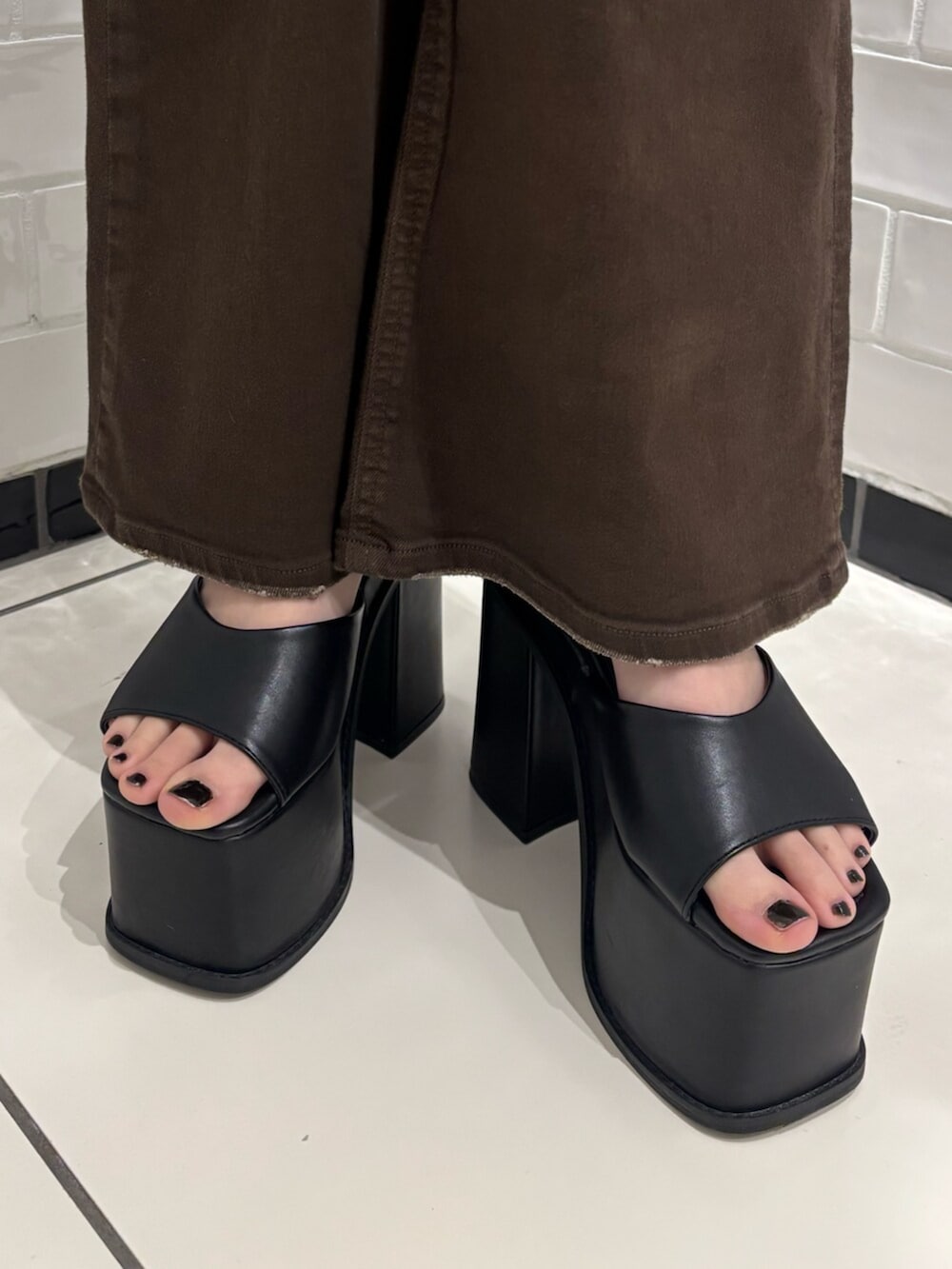 ブラック系のサンダル、ブラウン系のサロペット/オーバーオール、ブラック系のニット/セーターを着用したレディースの春コーディネートの6枚目の写真