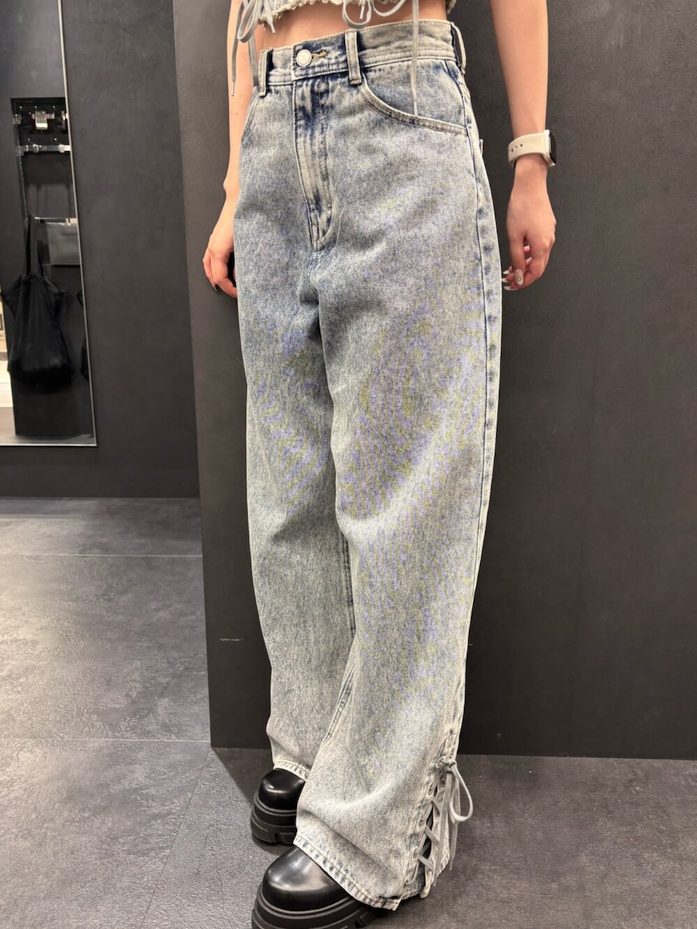 ブラック系のブーツ、ブルー系のタンクトップ、ブルー系のデニムパンツを着用したレディースの春コーディネートの5枚目の写真