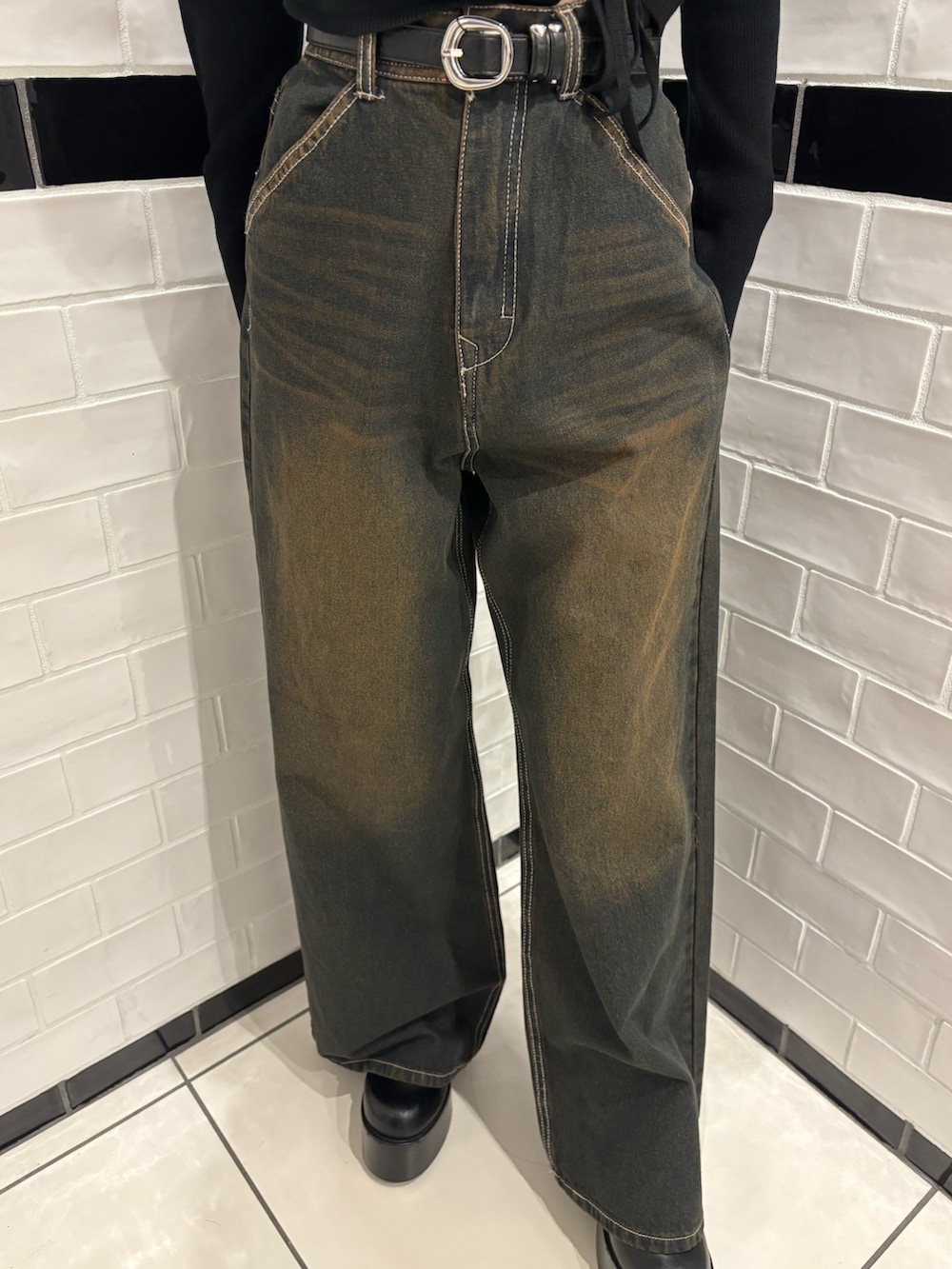 ブラック系のニット/セーター、ブルー系のデニムパンツ、ブラウン系のハンドバッグを着用したレディースの冬コーディネートの5枚目の写真