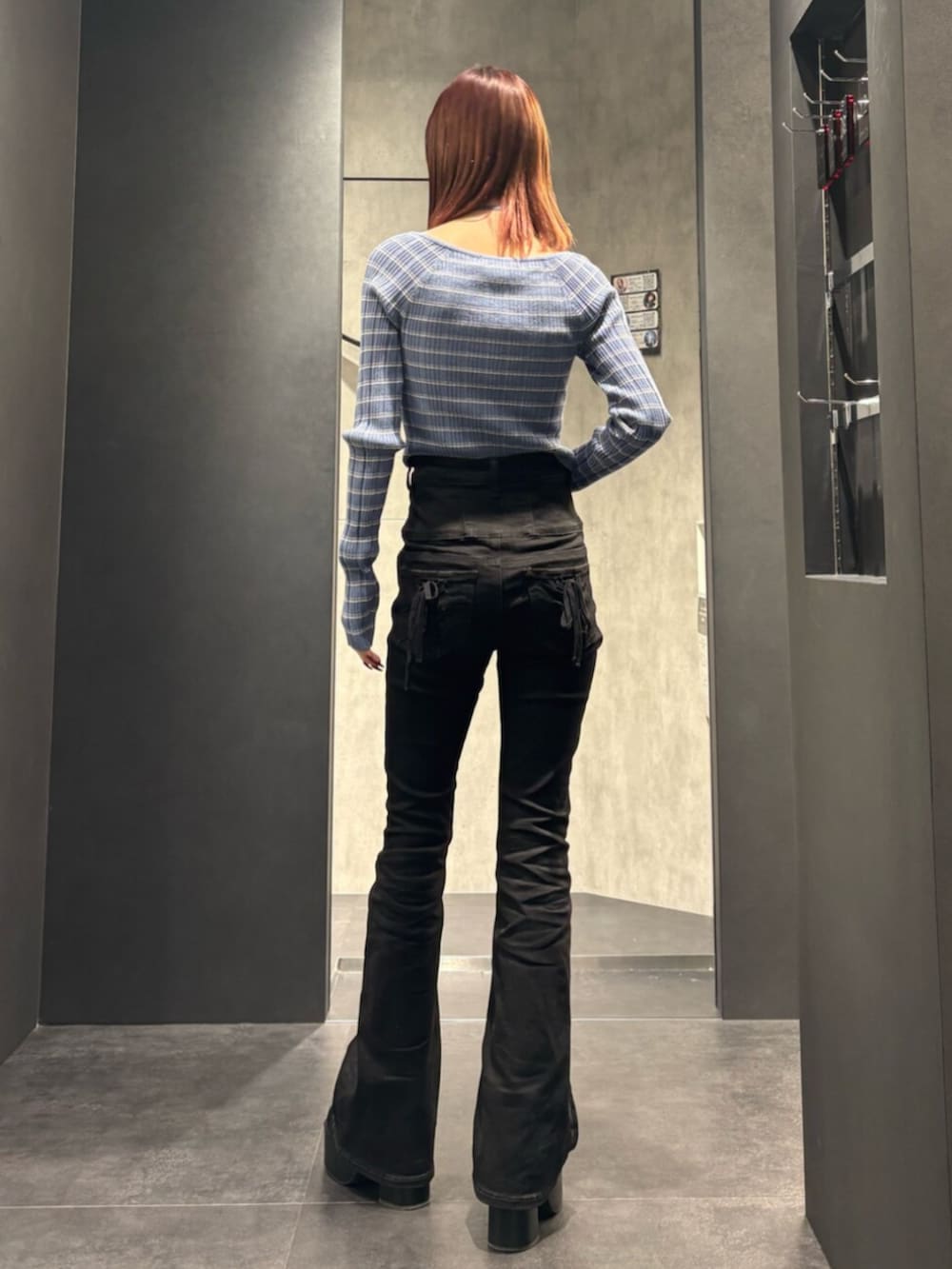 ブラック系のブーツ、ブラック系のデニムパンツ、ブルー系のニット/セーターを着用したレディースの冬コーディネートの3枚目の写真