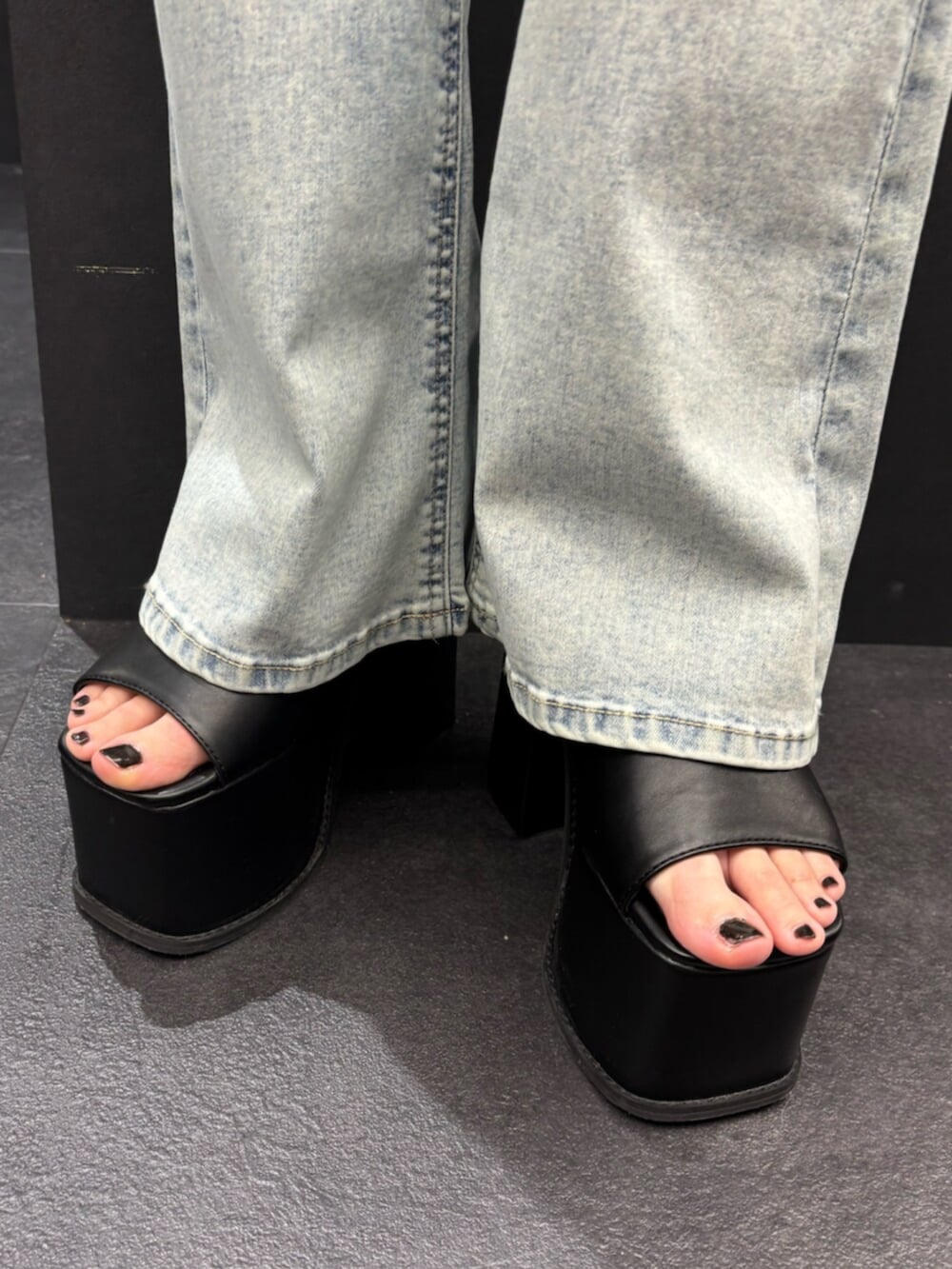 ブラウン系のハンドバッグ、ブラック系のサンダル、ブルー系のデニムパンツを着用したレディースの春コーディネートの6枚目の写真