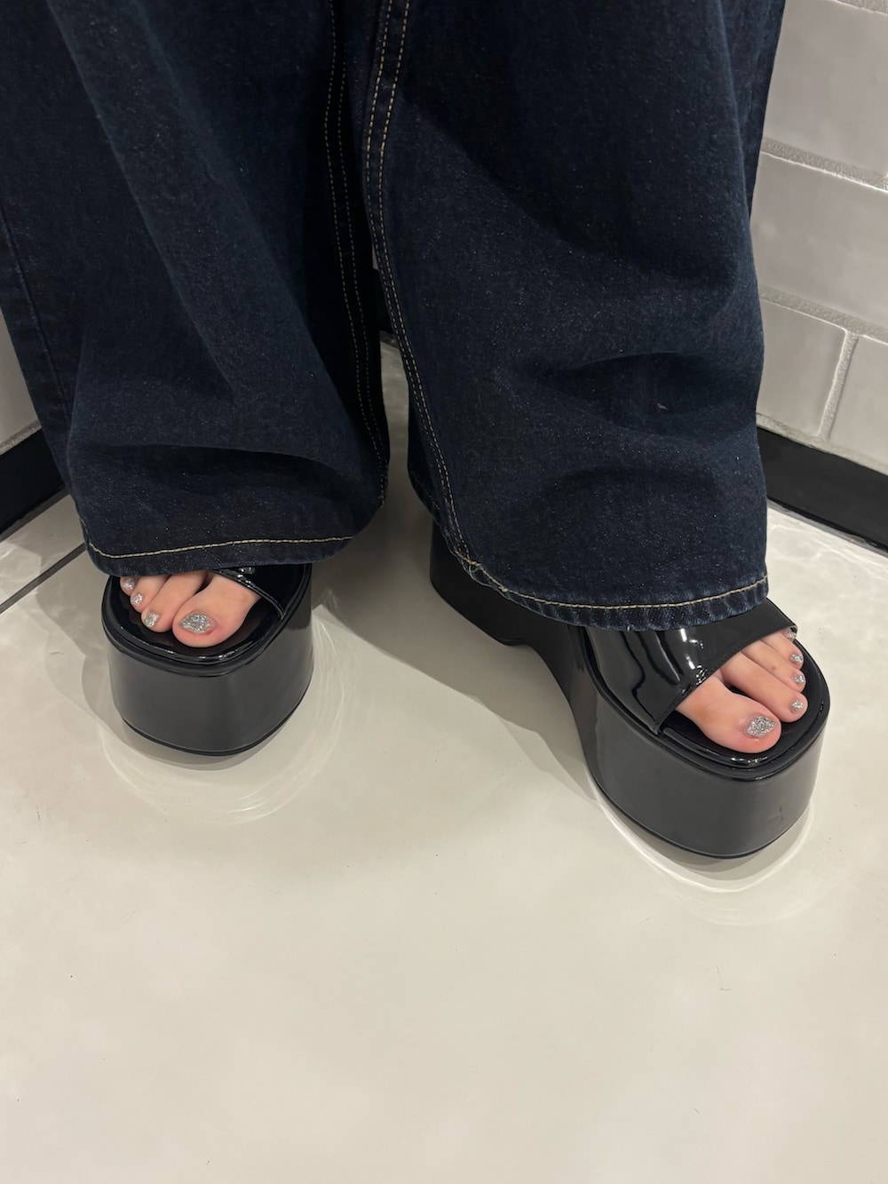 ピンク系のニット/セーター、ブルー系のデニムパンツ、ブラック系のショルダーバッグを着用したレディースの夏コーディネートの6枚目の写真