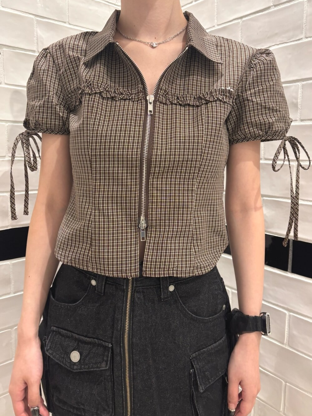 ブラック系のスカート、ブラック系のショルダーバッグ、ブラウン系のTシャツ/カットソーを着用したレディースの夏コーディネートの4枚目の写真