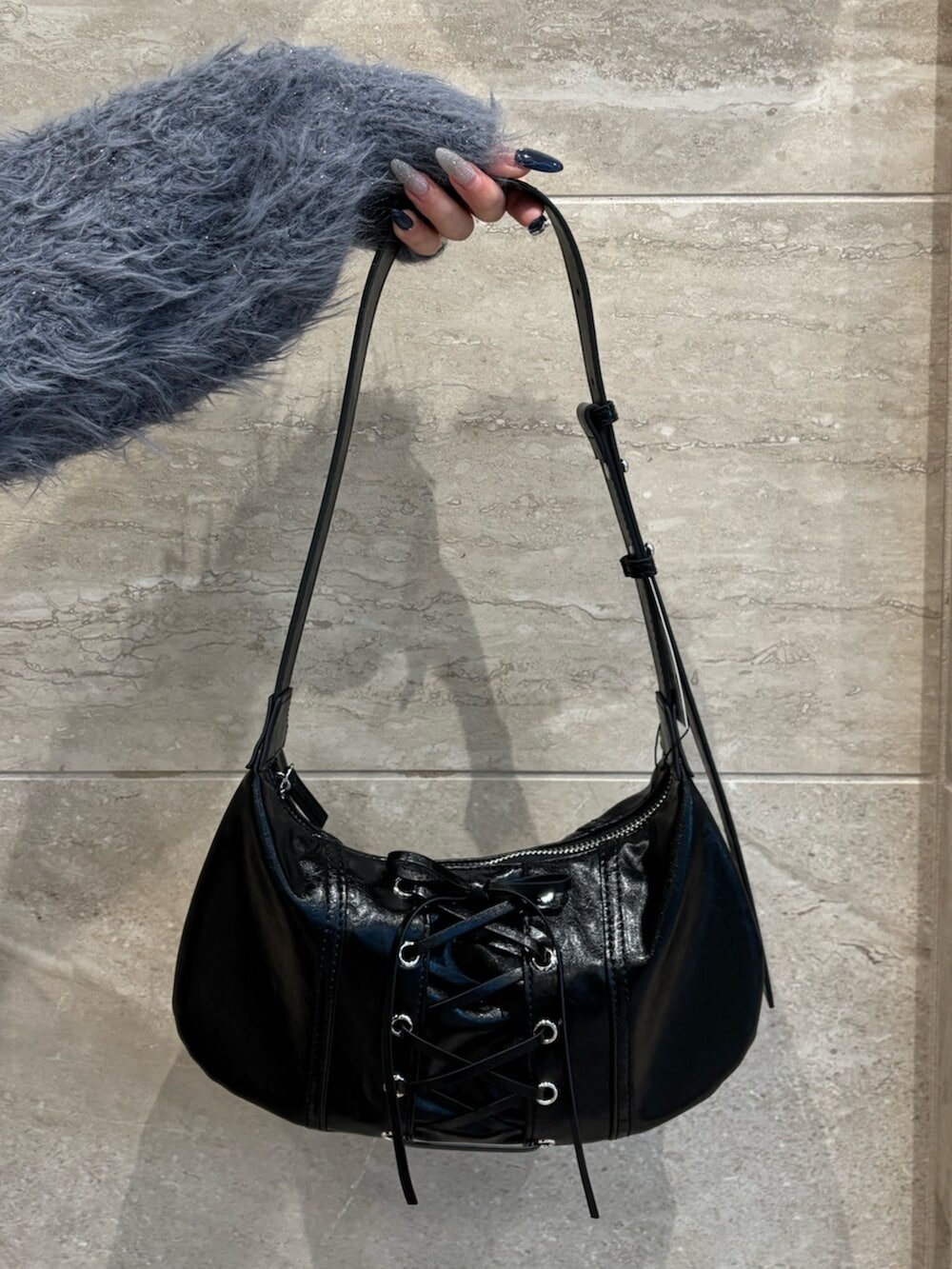 ブラック系のブーツ、グレー系のニット/セーター、ブラック系のデニムパンツを着用したレディースの冬コーディネートの8枚目の写真