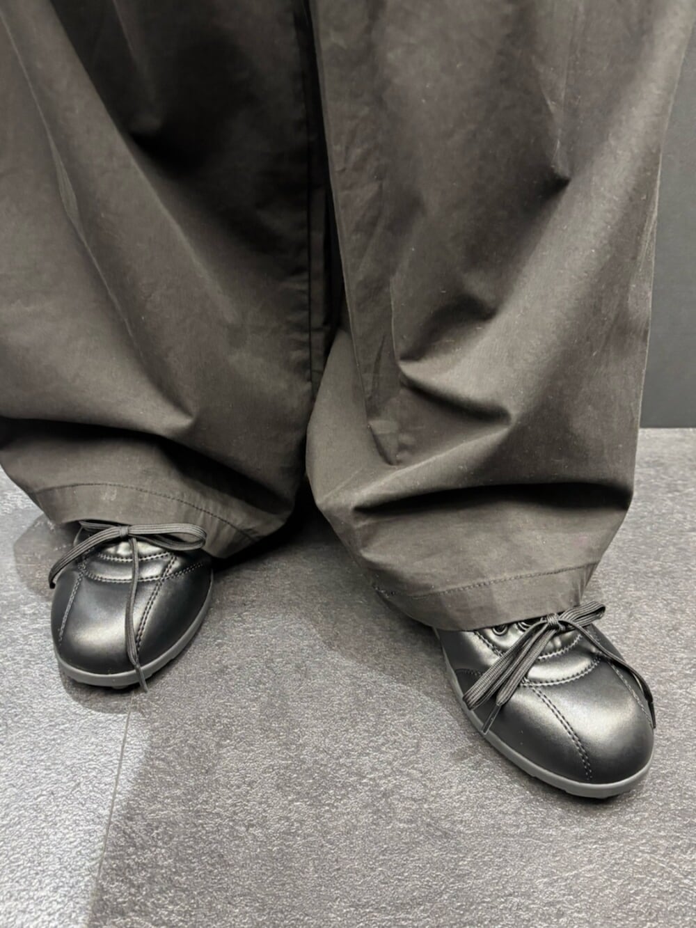 ブラック系のスニーカー、ホワイト系のTシャツ/カットソー、ブラック系のその他パンツを着用したレディースの春コーディネートの7枚目の写真