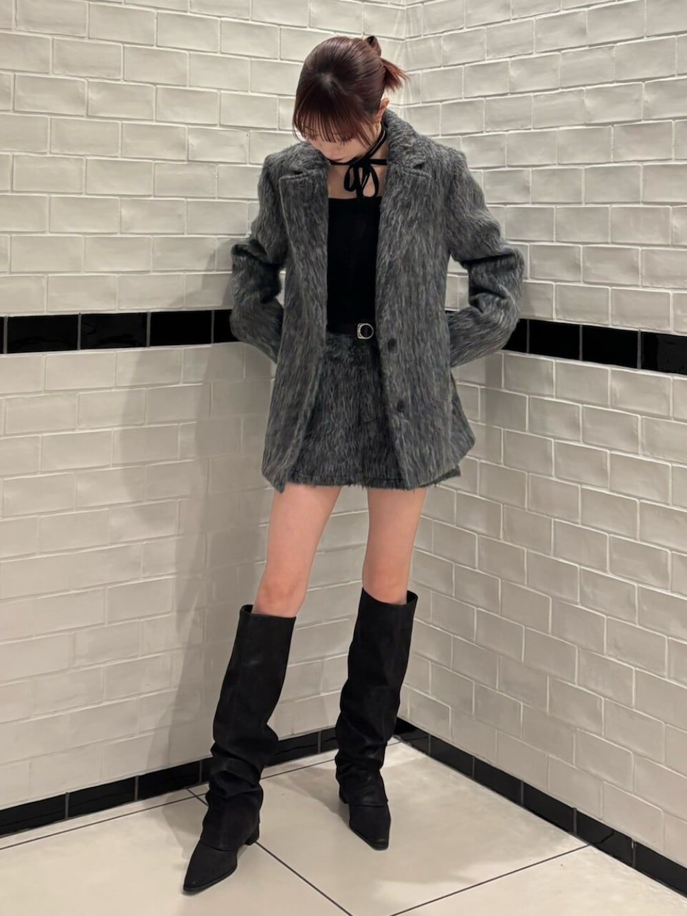 ブラック系のニット/セーター、グレー系のその他アウター、グレー系のその他パンツを着用したレディースの冬コーディネートの2枚目の写真