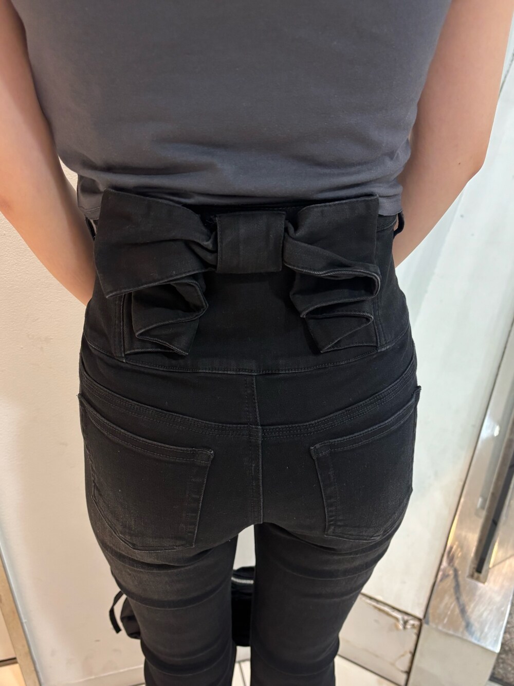 グレー系のTシャツ/カットソー、ブラック系のデニムパンツ、ブラック系のハンドバッグを着用したレディースの春コーディネートの6枚目の写真