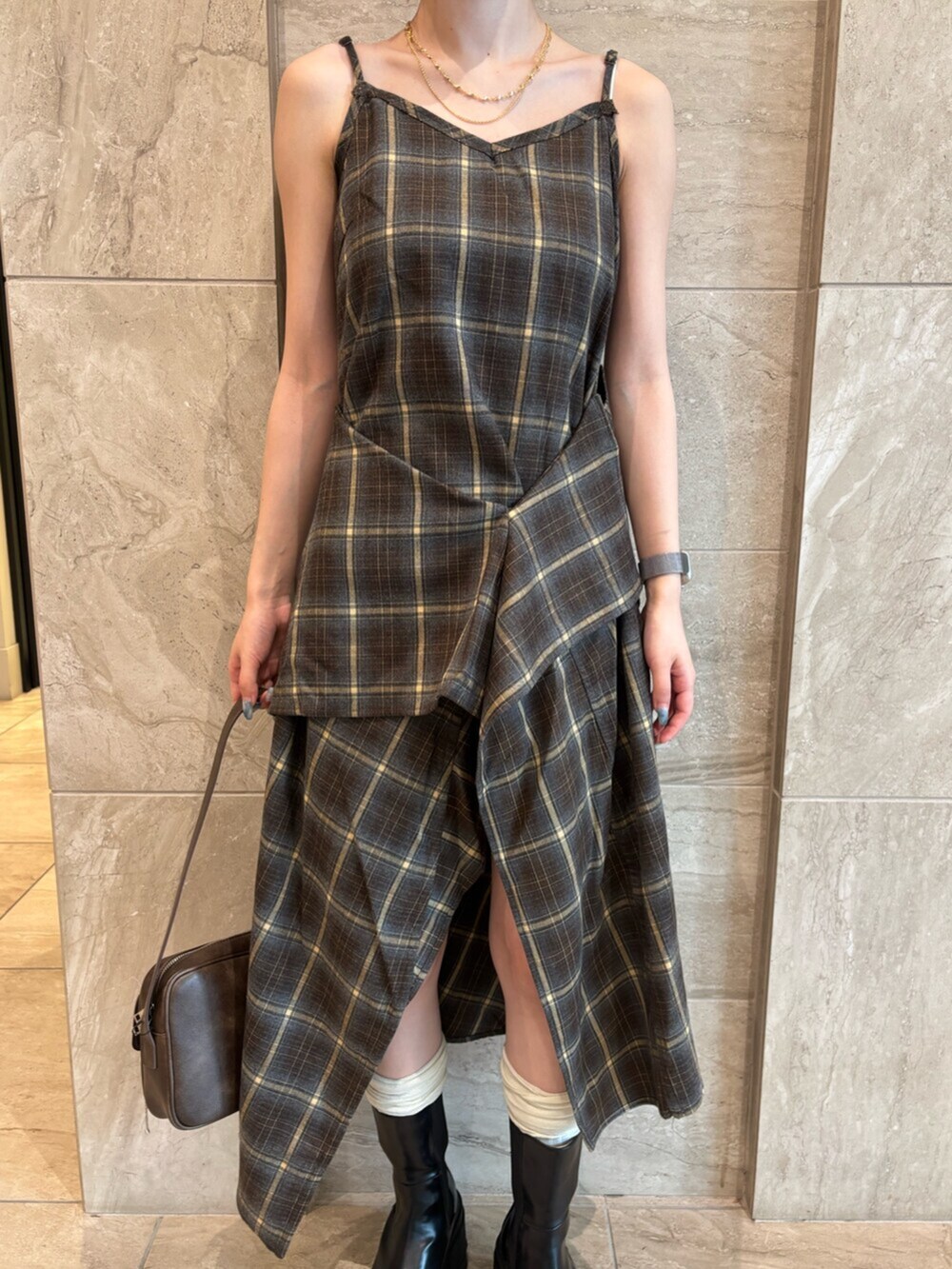 ブラウン系のハンドバッグ、グリーン系のワンピース、ブラック系のブーツを着用したレディースの夏コーディネートの5枚目の写真