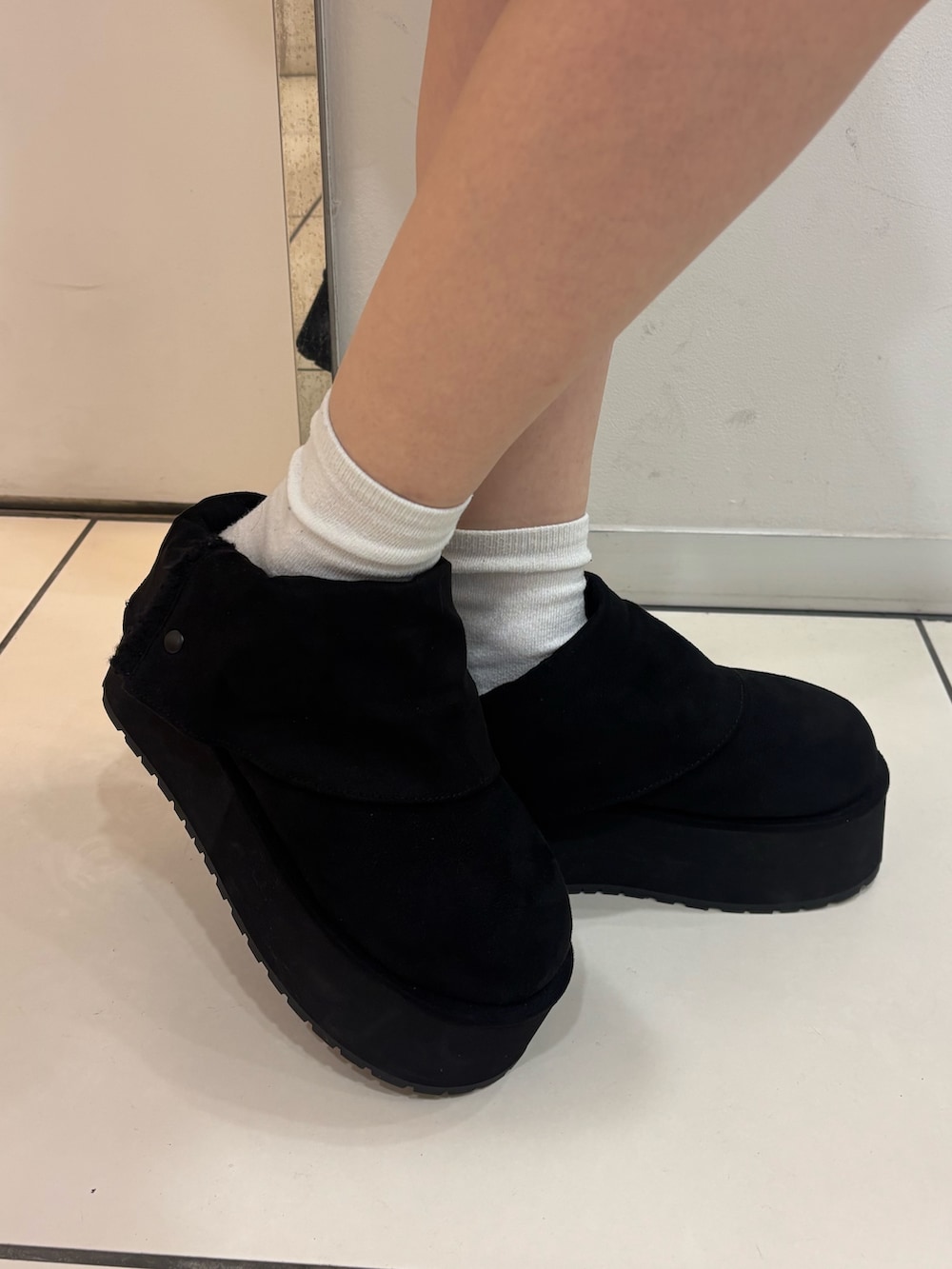 ブラウン系のブルゾン、ホワイト系のニット/セーター、ブラック系のスカートを着用したレディースの秋コーディネートの7枚目の写真