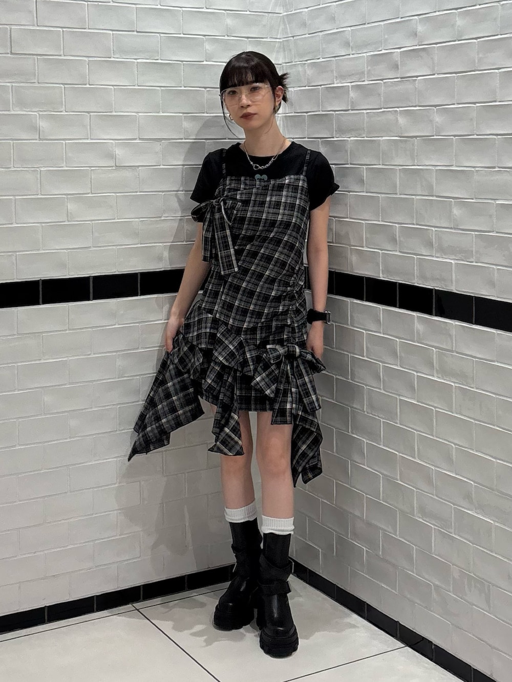 ブラック系のワンピース、ブラック系のブーツ、シルバー系のサングラスを着用したレディースの夏コーディネートの2枚目の写真