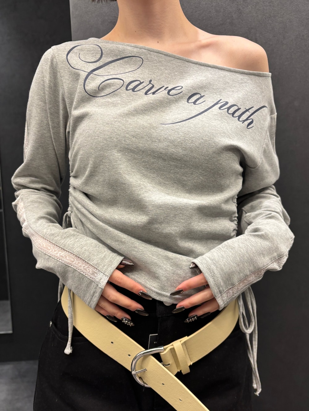 ブラック系のスカート、ブラック系のサンダル、グレー系のTシャツ/カットソーを着用したレディースの春コーディネートの4枚目の写真