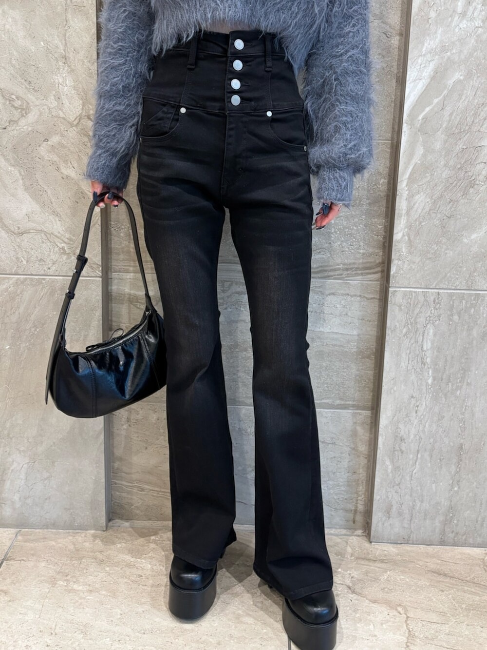 ブラック系のブーツ、グレー系のニット/セーター、ブラック系のデニムパンツを着用したレディースの冬コーディネートの6枚目の写真