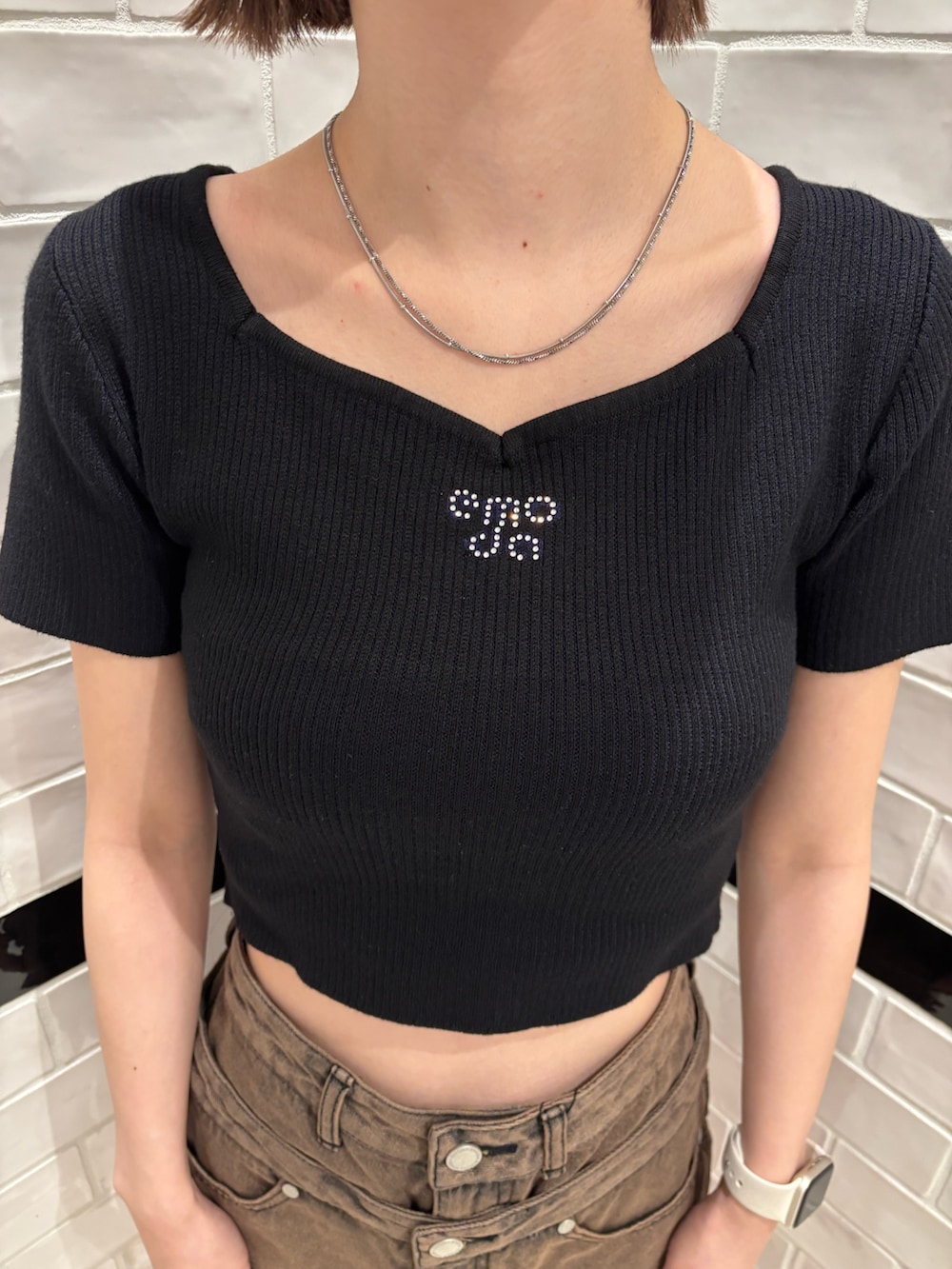 ブラック系のニット/セーター、ブラウン系のスカート、ブラック系のサンダルを着用したレディースの春コーディネートの5枚目の写真