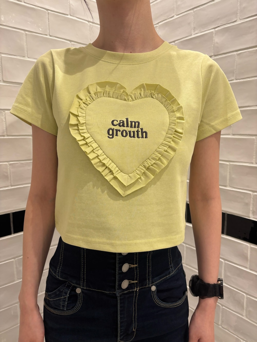 イエロー系のTシャツ/カットソー、ブルー系のデニムパンツ、ブラック系のサンダルを着用したレディースの夏コーディネートの4枚目の写真
