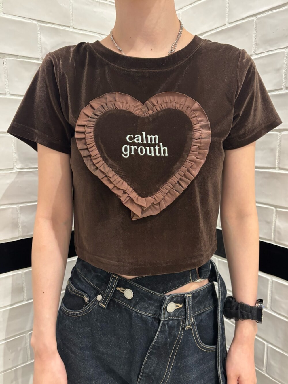 ホワイト系のショルダーバッグ、ブラウン系のTシャツ/カットソー、ブラック系のスニーカーを着用したレディースの夏コーディネートの4枚目の写真