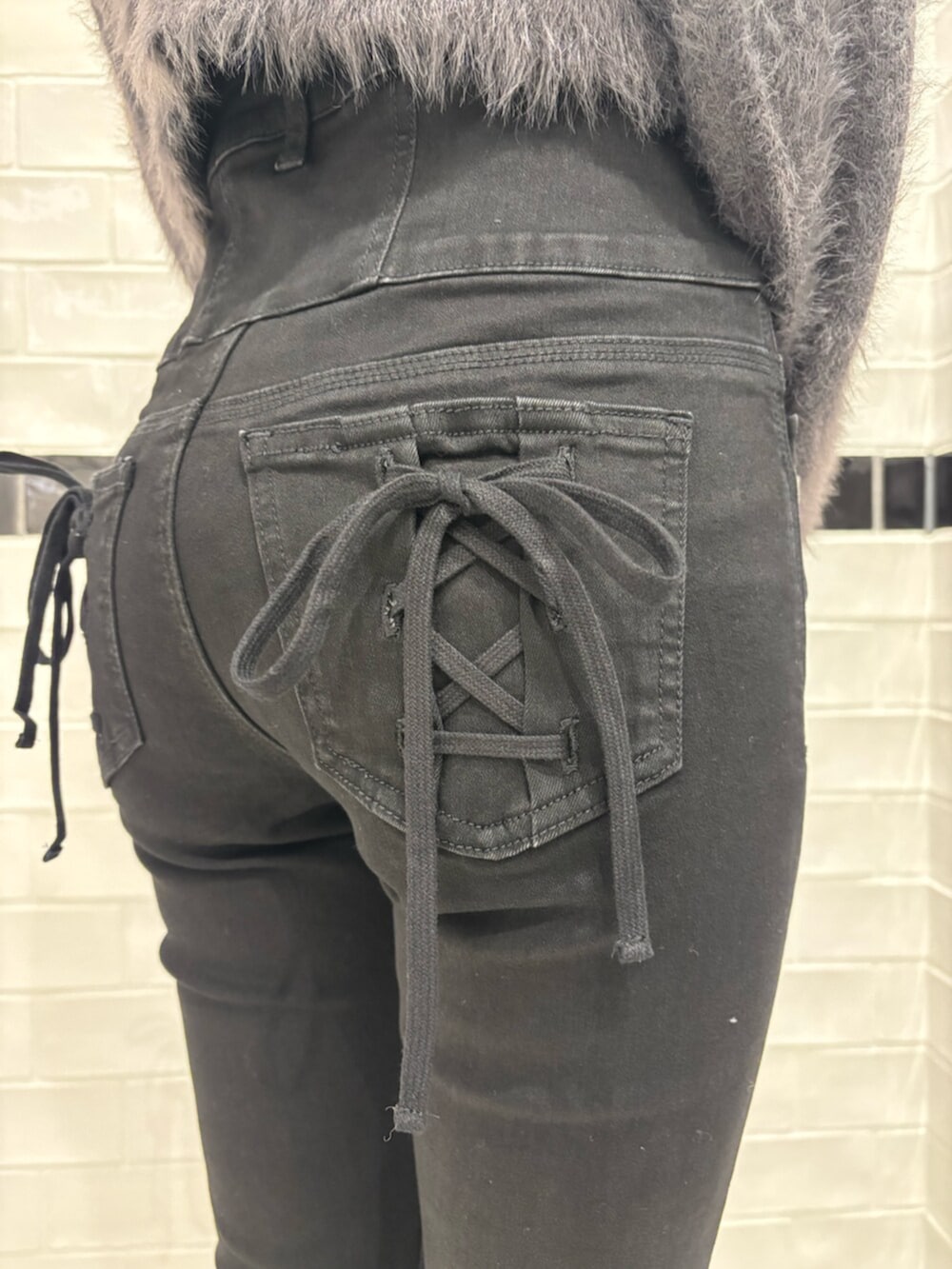 グレー系のニット/セーター、ブラック系のデニムパンツ、ブラック系のブーツを着用したレディースの秋コーディネートの6枚目の写真