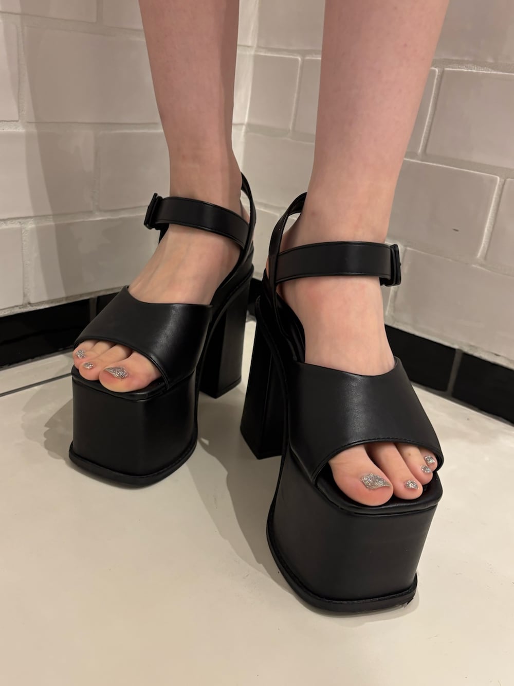 ブラック系のニット/セーター、ブラウン系のスカート、ブラック系のサンダルを着用したレディースの春コーディネートの7枚目の写真