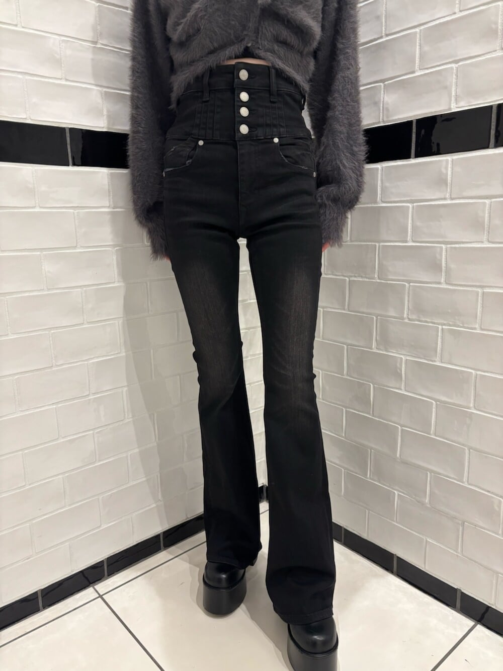 グレー系のニット/セーター、ブラック系のデニムパンツ、ブラック系のブーツを着用したレディースの秋コーディネートの5枚目の写真