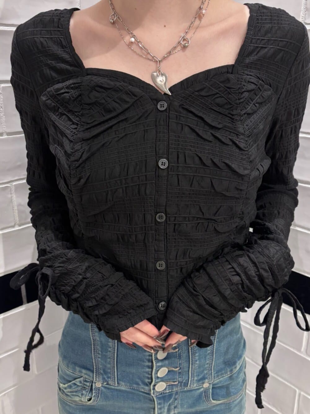 ブラック系のブーツ、ブラウン系のハンドバッグ、ブラック系のTシャツ/カットソーを着用したレディースの冬コーディネートの4枚目の写真