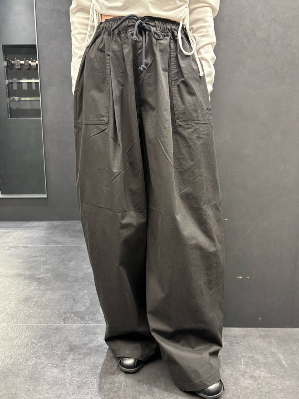 ブラック系のスニーカー、ホワイト系のTシャツ/カットソー、ブラック系のその他パンツを着用したレディースの春コーディネートの6枚目の写真