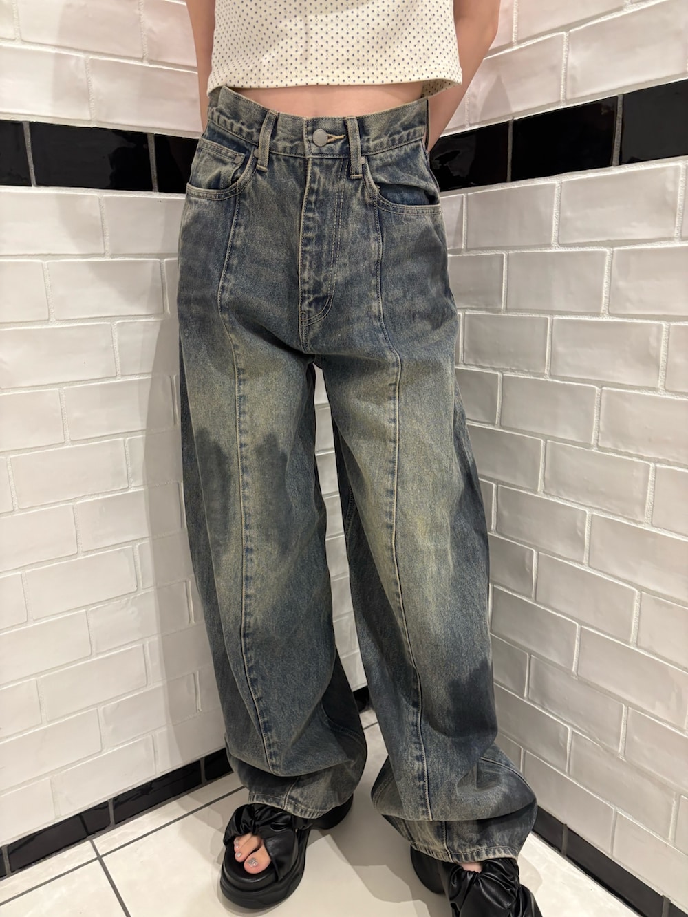 ホワイト系のタンクトップ、ブルー系のデニムパンツ、ブラック系のショルダーバッグを着用したレディースの夏コーディネートの5枚目の写真