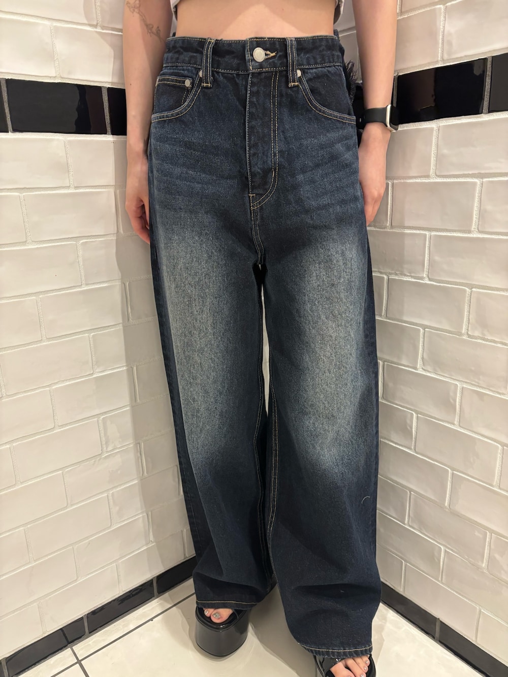 ピンク系のニット/セーター、ブルー系のデニムパンツ、ブラック系のショルダーバッグを着用したレディースの夏コーディネートの5枚目の写真