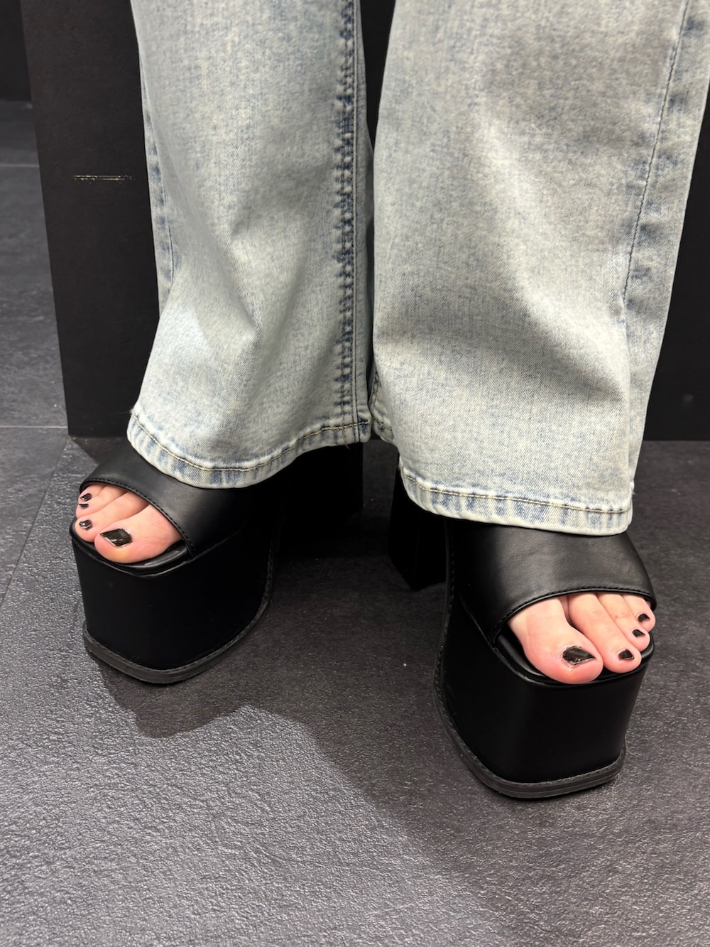 ブラック系のTシャツ/カットソー、ブルー系のデニムパンツ、ブラック系のサンダルを着用したレディースの春コーディネートの7枚目の写真