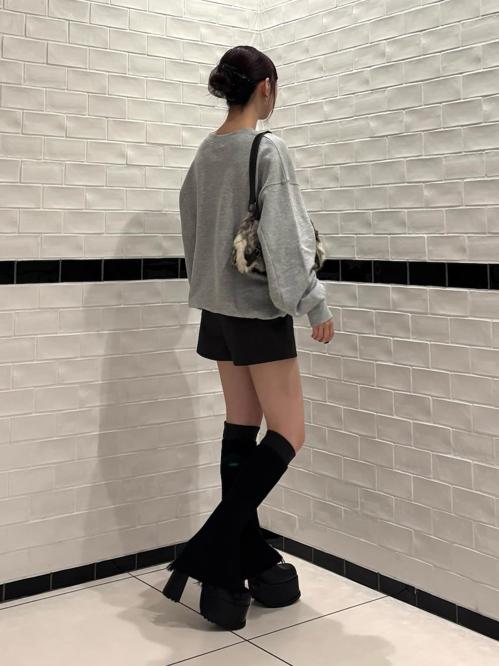 グレー系のスウェット、ブラウン系のその他パンツ、ブラック系のローファーを着用したレディースの秋コーディネートの2枚目の写真