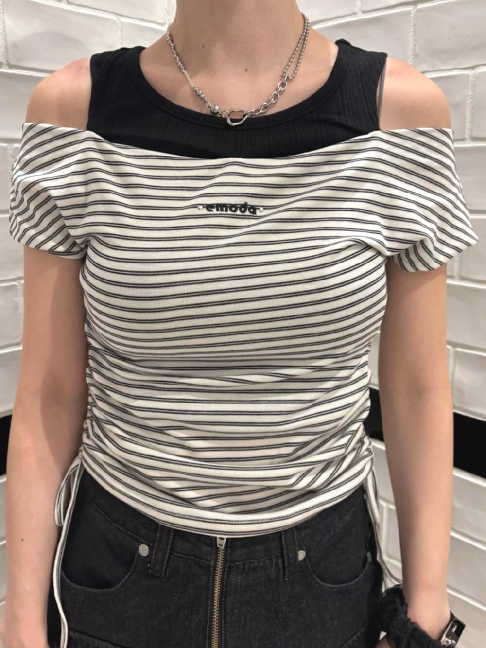 ブラック系のスニーカー、ブラック系のスカート、ホワイト系のTシャツ/カットソーを着用したレディースの夏コーディネートの4枚目の写真
